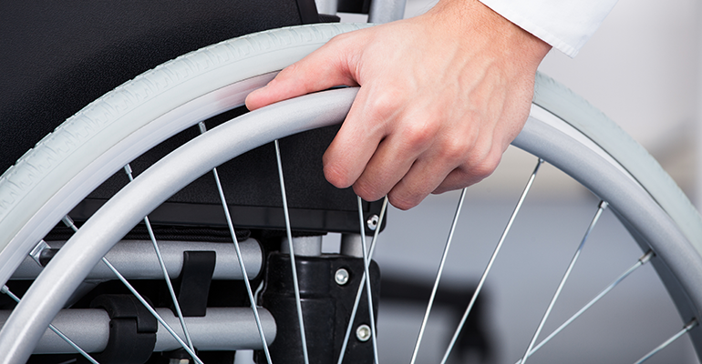 una mano empujando una silla de ruedas